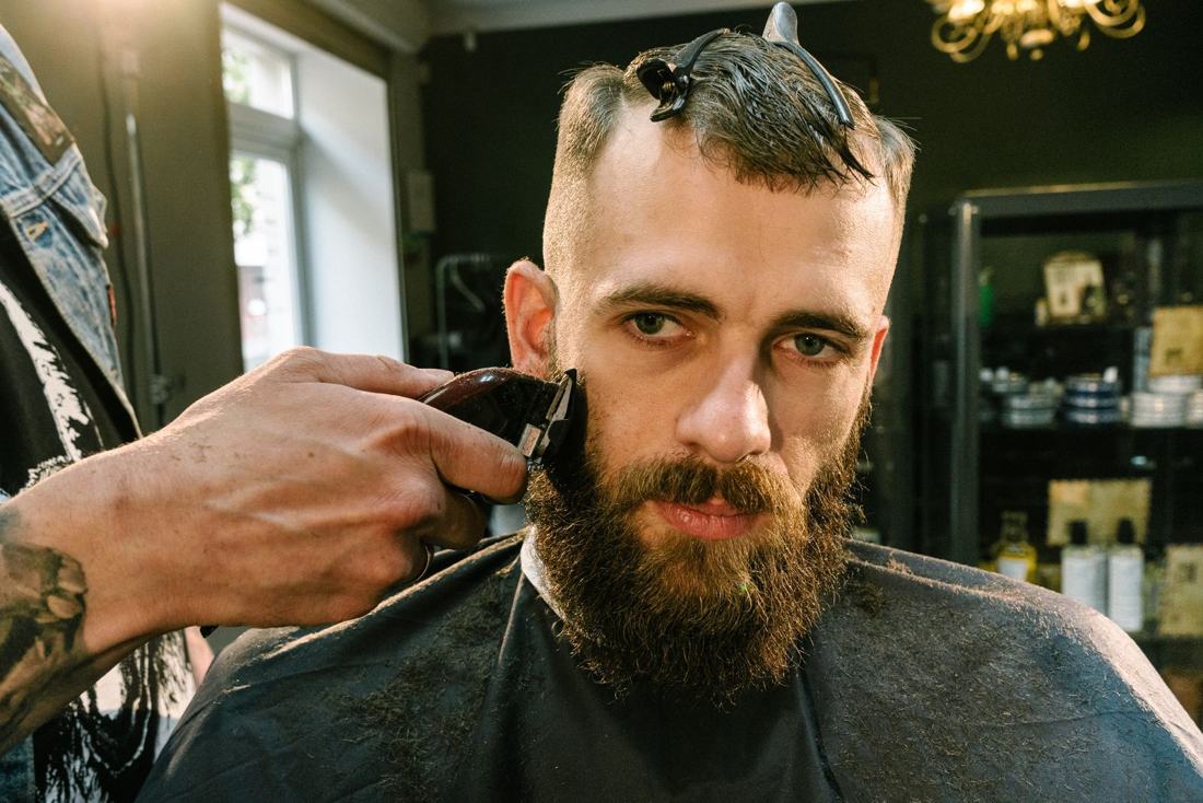 Close-up of clippers lining up a beard